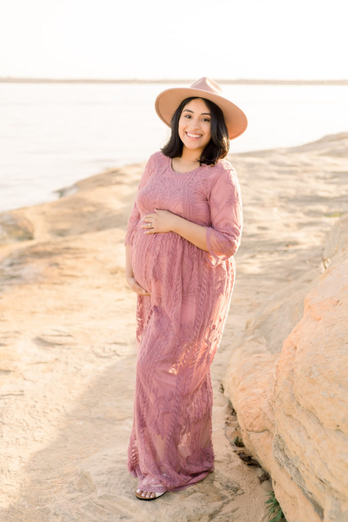 pregnant woman posing with her baby bump on the rocks of murrell park in flower mound for her maternity session