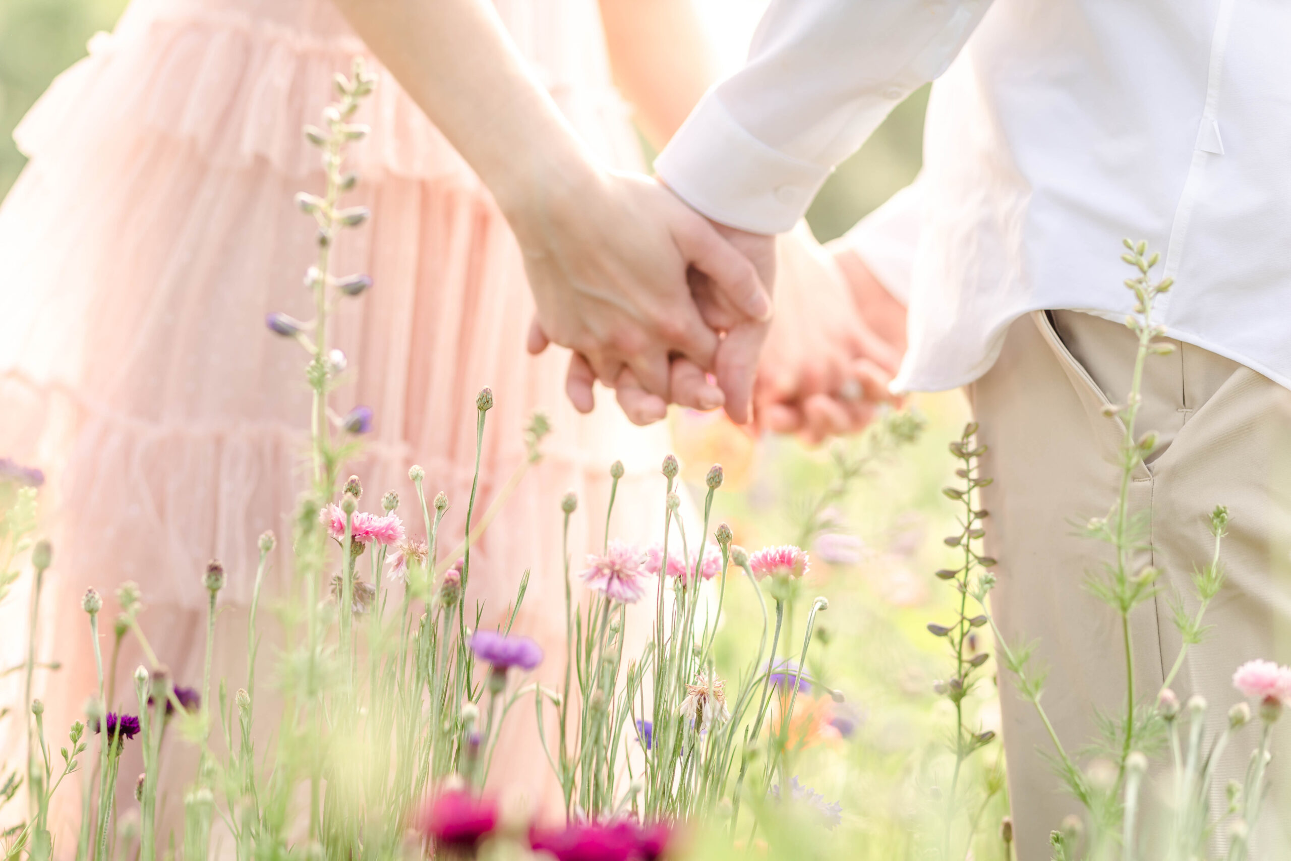 couple holding hands at wildflower field in dallas fortworth at a spring family portrait session